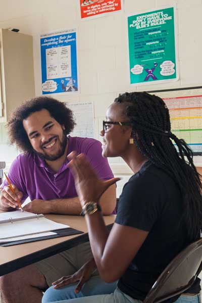 two happy v.c.u. students chatting in a classroom